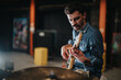 © qunica.com - A performer is playing the guitar during a rehearsal, preparing for an upcoming concert in a professional studio. The setting reflects creativity and dedication to musical artistry in a lively