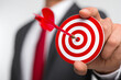 © Luluraschi - professional manager displaying target with accurate arrow strike in bullseye, business success metaphor