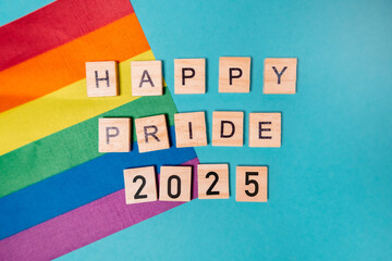 Poster - Rainbow flag is on a blue background with the words Happy Pride 2025