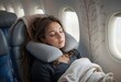 © Yurii - Woman sleeping on airplane window seat using gray travel pillow, soft blanket, natural light, peaceful mood.