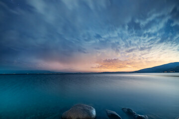 Wall Mural - Beautiful night landscape, long exposure clouds over the lake. Starry night. 