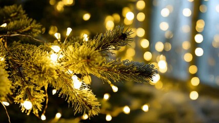 Aufkleber - Festive mood: a fir branch covered with snow glows with warm lights, creating a cozy and magical Christmas atmosphere, against a backdrop of blurred garland lights.