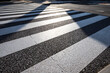 © Emongrapic - Abstract pattern of sunlight and shadow on a pedestrian crossing on an asphalt road
