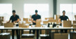 © birulaut - Three people packing boxes in a warehouse or distribution center.