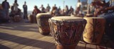 An outdoor drum circle with musicians playing traditional percussion instruments surrounded by an attentive crowd, evoking a sense of community and rhythm.
