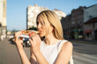 © DaliCeMedia - A young and happy blonde is eating a slice of pizza on the street