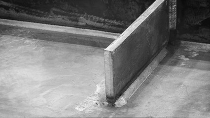 Poster - weld seam attaches a black metal part to another metal surface, metal welding industrial reliability and strength concept background