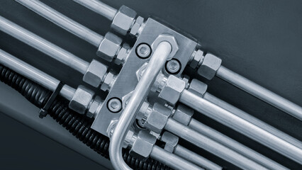 Poster - industrial concept background, bunch of pipes are connected to each other. pipes are silver and have many nuts and bolts, as part of an industrial drive hydraulic system