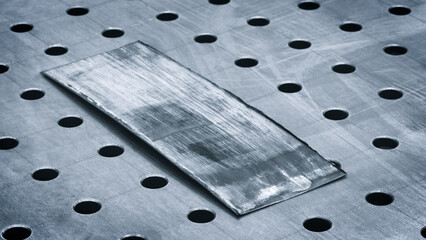 Poster - A metal sheet with a hole in it. The sheet is silver and has a lot of holes in it, ndustrial concept background
