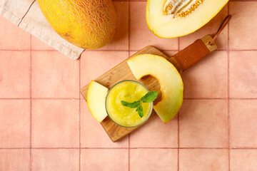 Wall Mural - Wooden board with glass of tasty melon smoothie and mint on pink tile table