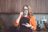 Woman enjoying espresso in her cozy kitchen during a relaxing coffee break