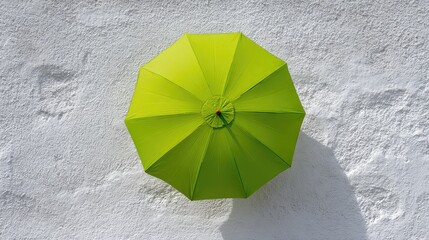 Poster - Bright Green Umbrella Against a White Wall, Offering a Cheerful Contrast and Enhancing a Fresh, Vibrant Atmosphere for Summer or Outdoor Settings