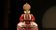 © Kamlesh - Ai generated image of a kathakali dancer in elaborate costume performs on a dark stage, his expression intense