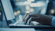 © W saputro - Close-up of hands typing on a laptop keyboard in a modern setting