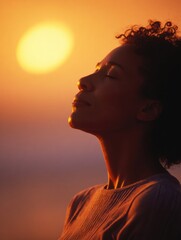 Poster - A woman sits outdoors, eyes closed and calm, meditating at sunset.