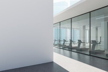 Fototapete - Modern gym interior with treadmills inside glass-walled fitness center in high-rise city building under clear daylight conditions. 3D Rendering
