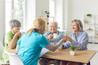 © Studio Romantic - Caregiver at a nursing home conducting a medical checkup and engaging in a conversation with a group of senior patients. Healthcare provided to the elderly people in such facilities.