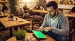 © Gilang - Young man browsing on tablet with green screen in a stylish coffee shop setting