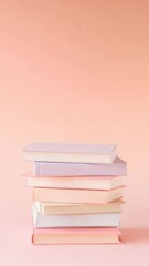 Poster - Pastel colored books are stacked neatly on a pink background, creating a visually appealing arrangement perfect for back to school promotions and educational content