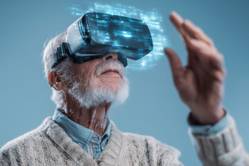 Fototapete - An older man is wearing a virtual reality headset and playing a game