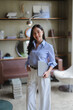 © Parichat - Portrait of a smiling businesswoman holding a laptop in a modern office