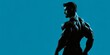 © Yaroslav Herhalo - The silhouette shot displays the muscular man in an athletic pose, illuminated with dramatic studio lighting over a bold blue backdrop.
