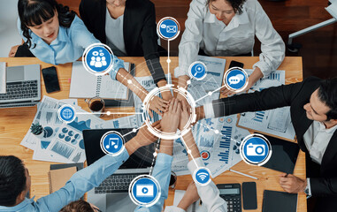 Poster - A diverse business team collaborates around a wooden table equipped with technology, engaging with charts and digital tools to drive innovative solutions and success. Amity