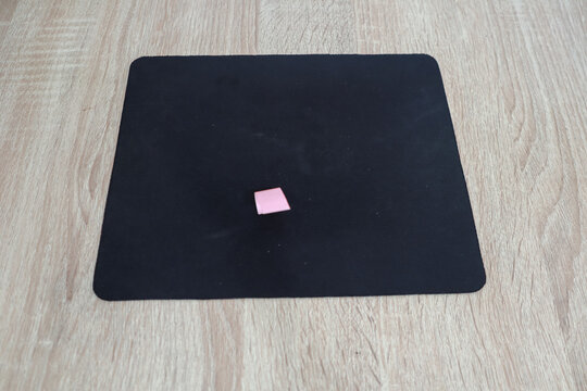 Pink Square on Black Mousepad on Wooden Surface