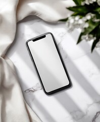 Poster - Modern smartphone with blank screen placed on marble surface surrounded by white fabric and green plant for technology and communication concept