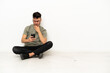 © luismolinero - Young caucasian man sitting on the floor isolated on white background thinking and sending a message