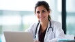 © ittipol - Smiling Doctor with Laptop: A friendly doctor, radiating professionalism and approachability, is captured while working diligently on her laptop.