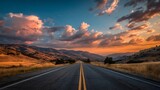 まっすぐ続く山間の道路と夕焼けの空
