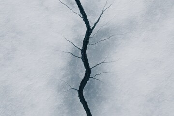 Wall Mural - frozen river with a prominent ice fracture captured from above during a chilly winter dawn