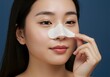 © SITI - Asian Woman Applying Nose Pore Strip for Deep Cleansing Skincare Routine