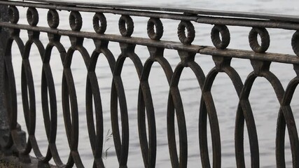 Poster - A close-up shot of a metal fence surrounded by a body of water, great for use in travel or nature photography