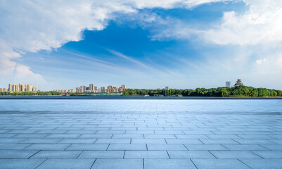 Wall Mural - empty square floor and city skyline with a beautiful park by the lake under blue sky