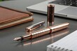 © Nadimul - Elegant rose gold fountain pen with notebook and laptop writing instrument