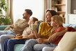© Goran - Happy parents and their kids day dreaming while relaxing on sofa at home.