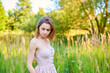 © SergeiPh - A beautiful woman stands in the forest on a summer day. A white dress and transparent panties are dressed on it. The scene is peaceful and serene when the girl is surrounded by nature