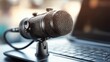 © somsri - Close-up of USB microphone with cable connected to laptop for home recording