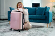 © PaeGAG - Happy businesswoman is ready for business trip, hugging her pink suitcase
