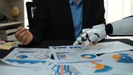 Poster - a businessman collaborates with a robotic arm to analyze financial reports, demonstrating the fusion