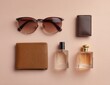 © SAYEM - A flat lay of men's accessories, including sunglasses, a leather wallet, and a perfume bottle, on a pastel pink background. The focus is placed in the center, with the items.