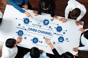 Aufkleber - A group of business professionals engages in a collaborative meeting, analyzing an omni-channel strategy on a large table, showcasing diverse marketing concepts and insights for growth. Amity