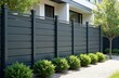 © Maryna - Modern grey aluminum fence protects residential property garden. Stylish barrier home exterior design, secure privacy. Contemporary design offers aesthetic appeal. Landscape view with green bushes
