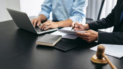 Aufkleber - Two people are sitting at a desk with a laptop and a book