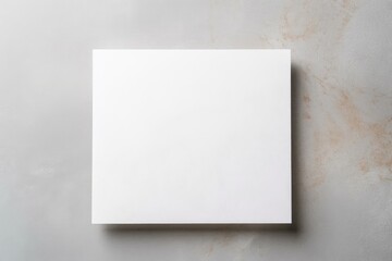 Poster - Empty white paper sheet resting on gray marble background providing copy space for text or artwork
