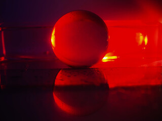 Wall Mural - a clear glass ball is sitting on a pedestal. colorful background. abstract graphic background. light
