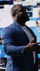 Poster - Vertical Video African American public speaker on stage surrounded by digital visuals, symbolizing a global conference where trends, mobile apps and AI powered content dominate modern communication