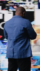 Poster - Vertical Video Young black professional explores a tech driven environment with visual data, content feeds and applications. Symbolizing entertainment, social reach and digital transformation. Camera